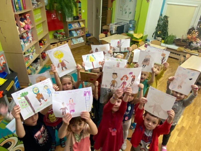 Przedszkolaki pozują do zdjęcia, w rękach trzymają wykonane przez siebie prace.