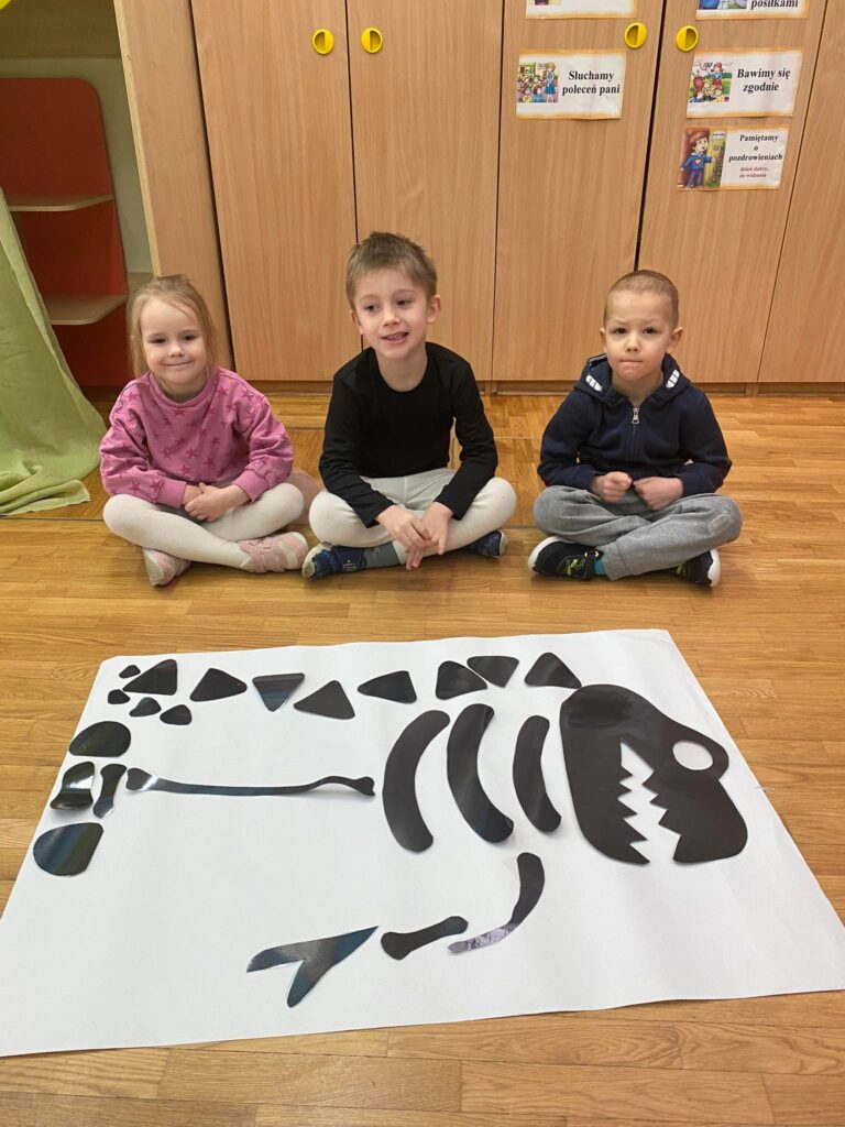 Dzieci z ułożonym przez siebie szkieletem dinozaurów.