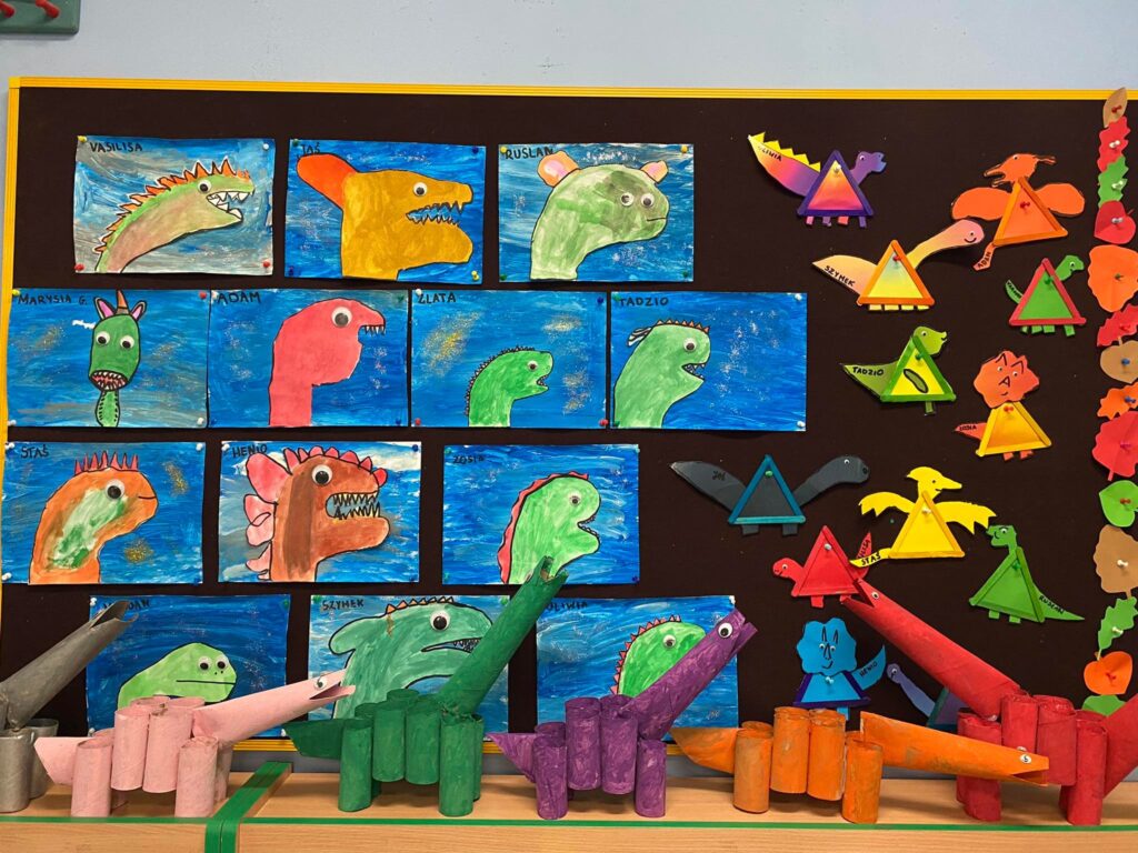 Prace plastyczne "Dinozaury farbami" wywieszone w szatni przedszkola.