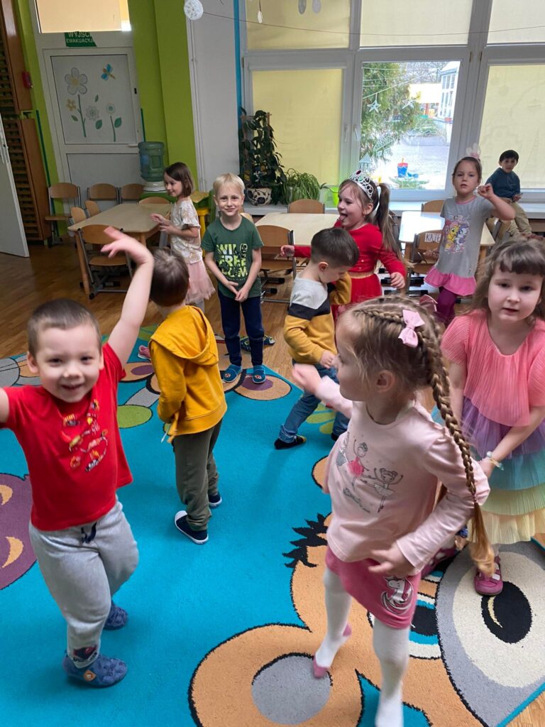 Dzieci tańczą do wesołej muzyki.
