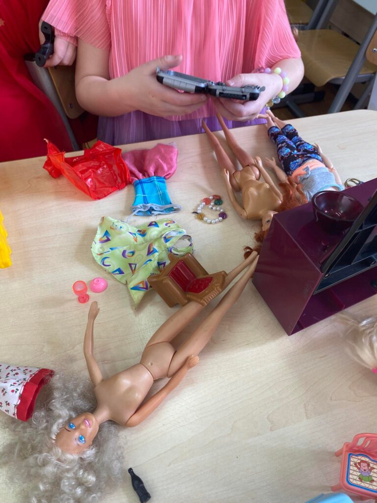 Dzieci bawią się lalkami barbie.