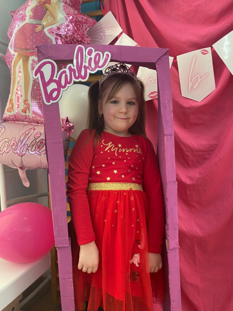 Pamiątkowe zdjęcie dziewczynki w foto budce Barbie.