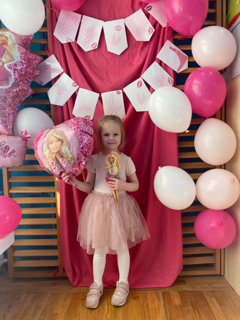 Pamiątkowe zdjęcie dziewczynki w foto budce Barbie.