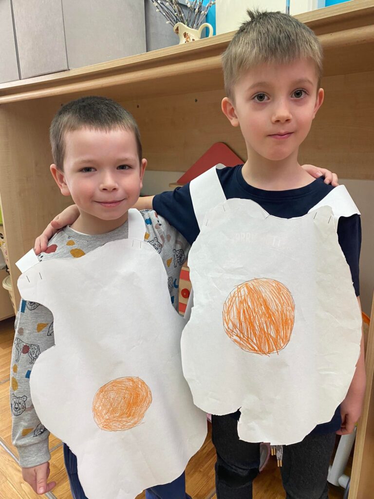Dwoje dzieci pozuje do zdjęcia w strojach jajek.