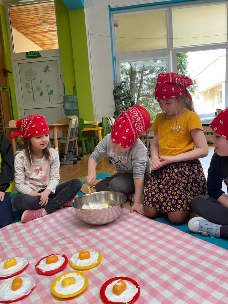 Dziecko dodaje do miski składniki pasty jajecznej.