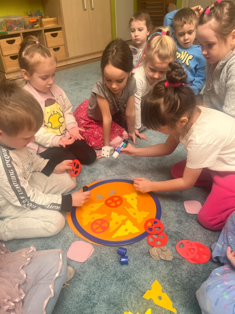 Dzieci układają papierową pizzę